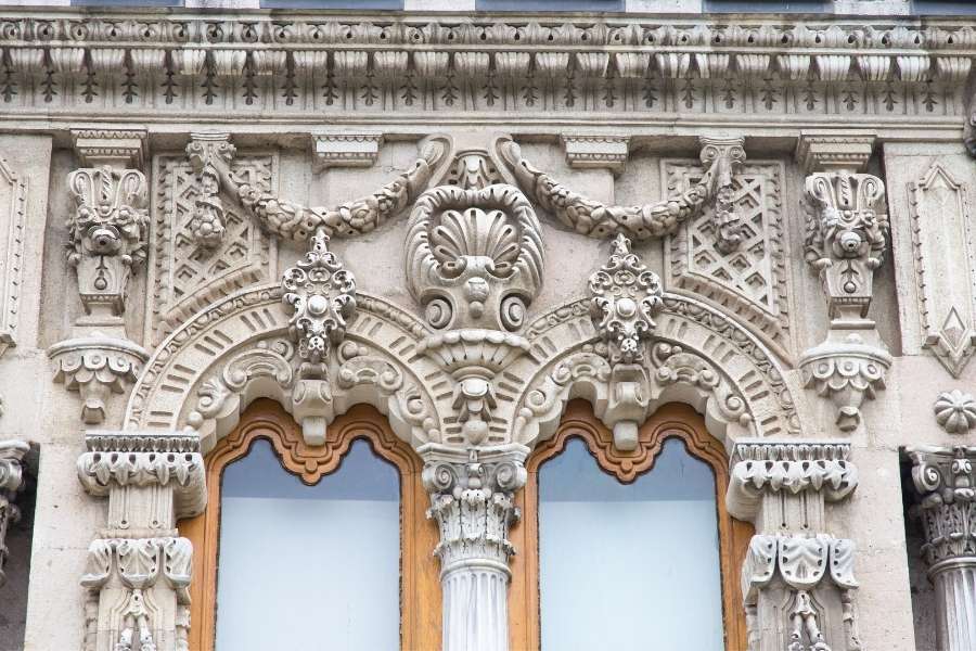 Close-up of intricate Ottoman-style stone carvings and decorative window details on a historic building facade in Istanbul.